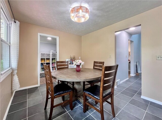145 Marylee Dr, Brighton Twp, PA 15009 - dining room featuring dark tile patterned flooring, a textured ceiling, and baseboards
