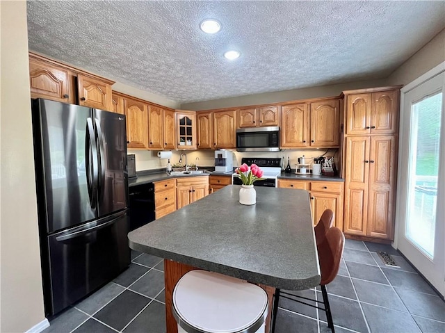 145 Marylee Dr, Brighton Twp, PA 15009 - kitchen with freestanding refrigerator, stainless steel microwave, dark countertops, stove, and a textured ceiling