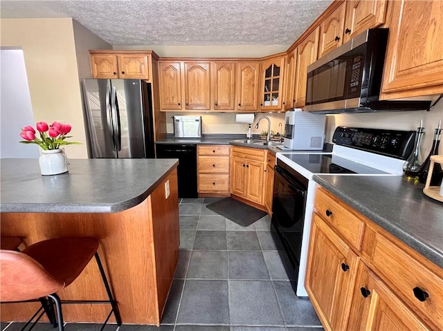 145 Marylee Dr, Brighton Twp, PA 15009 - kitchen with stainless steel appliances, dark countertops, glass insert cabinets, a breakfast bar area, and a textured ceiling
