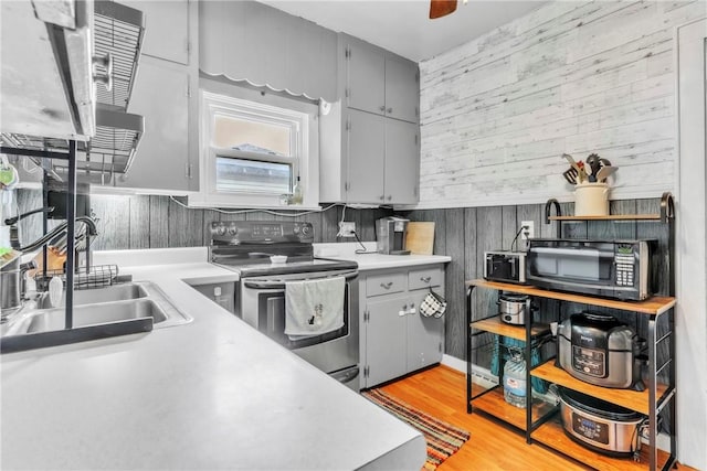 122 W Main St, Worthington, PA 16262 - kitchen with electric stove, black microwave, wood walls, and light countertops