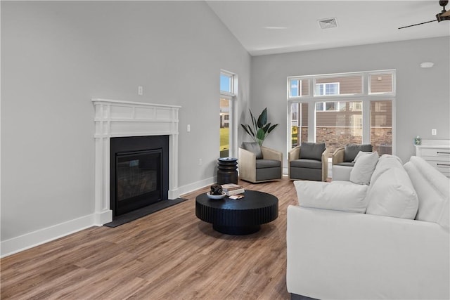 9002 Hickory Rd, Pine Twp Nal, PA 15044 - living room featuring lofted ceiling, light wood-style flooring, baseboards, and a glass covered fireplace