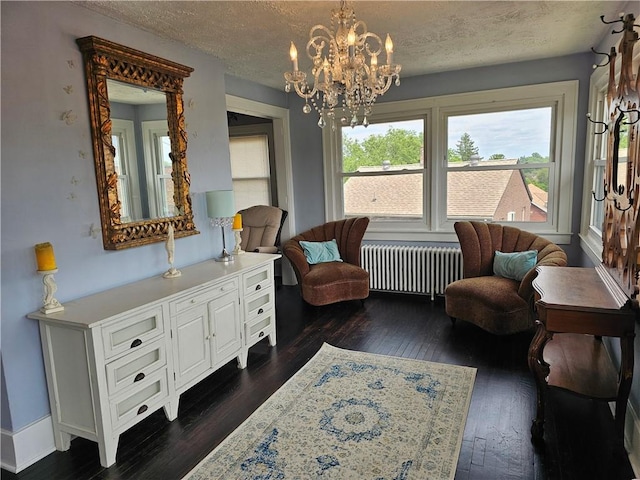 3213 Brownsville Rd, Brentwood, PA 15227 - living area with radiator heating unit, dark wood-style flooring, a chandelier, a textured ceiling, and baseboards