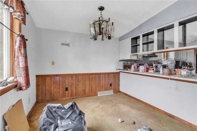 408 Mitchell Ave, City Of But Nw, PA 16001 - kitchen featuring a wainscoted wall, open shelves, a chandelier, wood walls, and tasteful backsplash