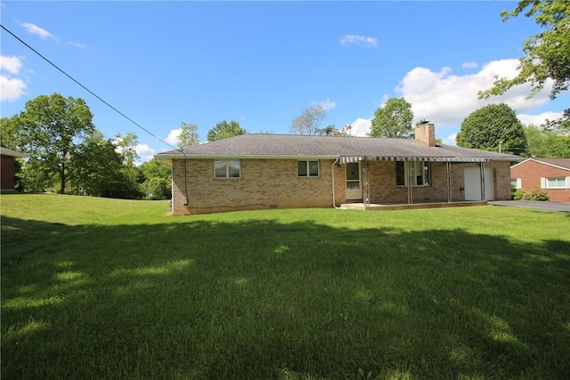 2224 Park Ave, Manor Twp, PA 16226 - back of property with a lawn, a chimney, an attached garage, brick siding, and driveway