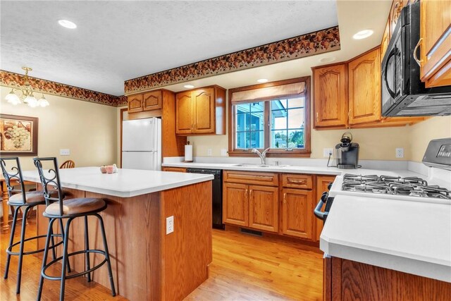 113 Sunburst Ct, Center Twp But, PA 16001 - kitchen featuring black appliances, light wood-type flooring, a breakfast bar, a sink, and a center island