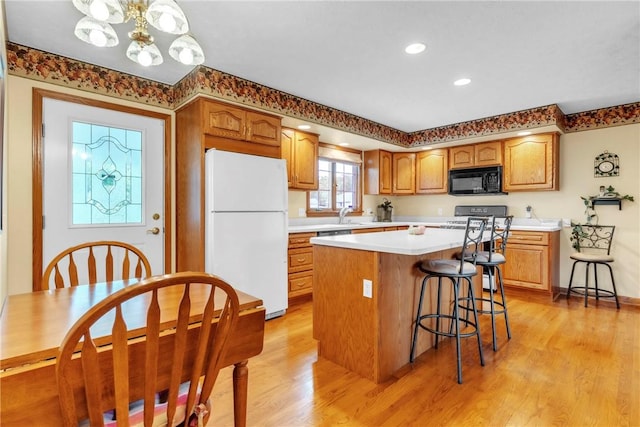 113 Sunburst Ct, Center Twp But, PA 16001 - kitchen with freestanding refrigerator, black microwave, a center island, light countertops, and light wood-style flooring