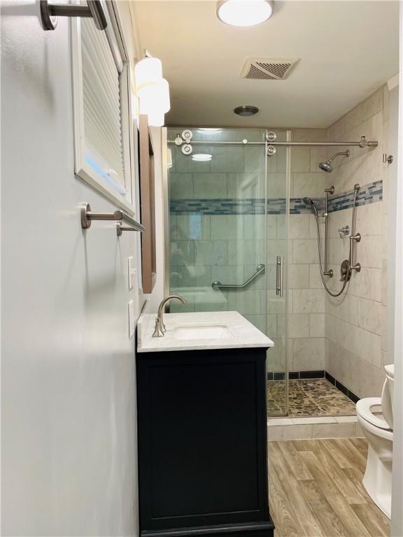 192 W Lincoln St, Waynsbrg/Frankln Twp, PA 15370 - full bathroom with toilet, a shower stall, vanity, and wood finished floors