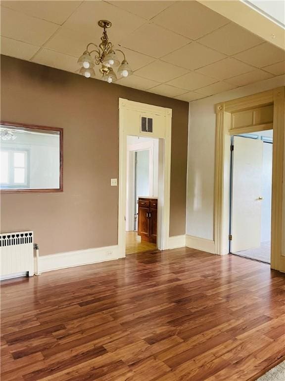 192 W Lincoln St, Waynsbrg/Frankln Twp, PA 15370 - unfurnished room featuring radiator heating unit, a chandelier, baseboards, wood finished floors, and a drop ceiling