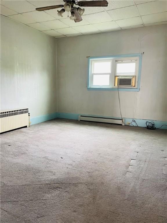 192 W Lincoln St, Waynsbrg/Frankln Twp, PA 15370 - carpeted empty room featuring radiator, baseboard heating, a ceiling fan, cooling unit, and a paneled ceiling