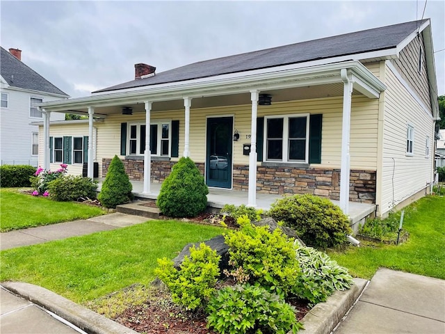 192 W Lincoln St, Waynsbrg/Frankln Twp, PA 15370 - view of front facade with stone siding, covered porch, a chimney, and a front lawn