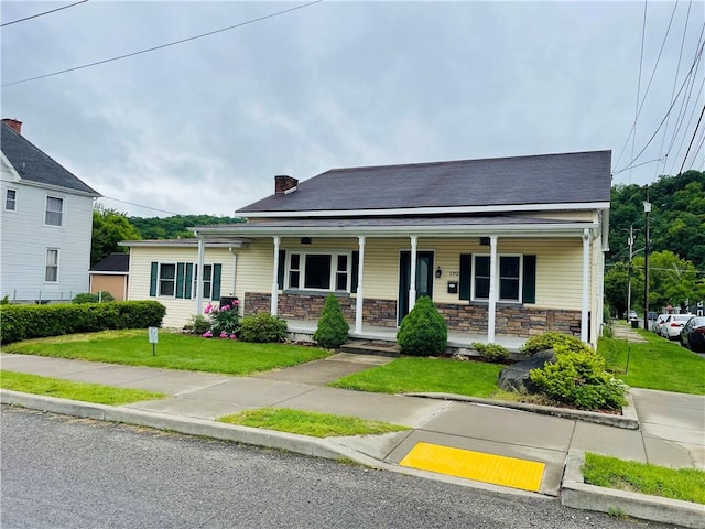192 W Lincoln St, Waynsbrg/Frankln Twp, PA 15370 - view of front of house with covered porch, stone siding, and a front yard