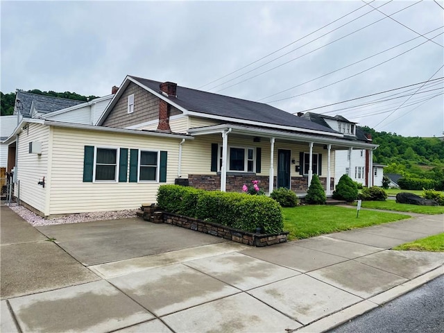 192 W Lincoln St, Waynsbrg/Frankln Twp, PA 15370 - view of front facade featuring a porch, a front yard, and a chimney