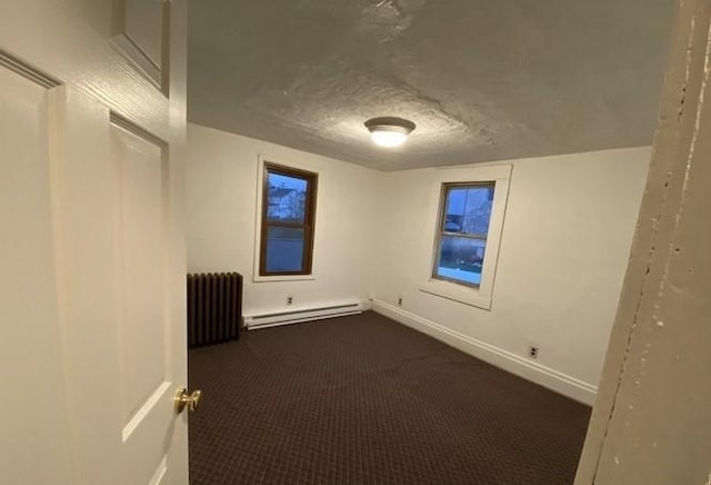 314 Lowell Unit 1/2, Vandergrift Wml, PA 15690 - spare room with baseboard heating, radiator, dark colored carpet, baseboards, and a textured ceiling