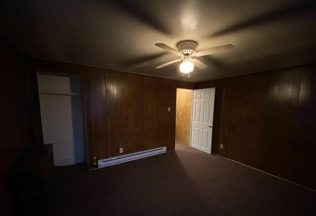 314 Lowell Unit 1/2, Vandergrift Wml, PA 15690 - unfurnished bedroom featuring a baseboard heating unit, wooden walls, carpet flooring, ceiling fan, and a closet