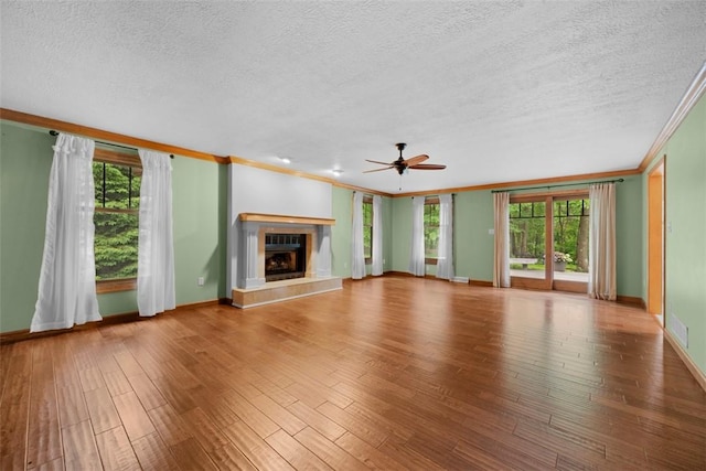 100 Firethorn Rd, Economy, PA 15005 - unfurnished living room with ornamental molding, a glass covered fireplace, healthy amount of natural light, wood finished floors, and a textured ceiling