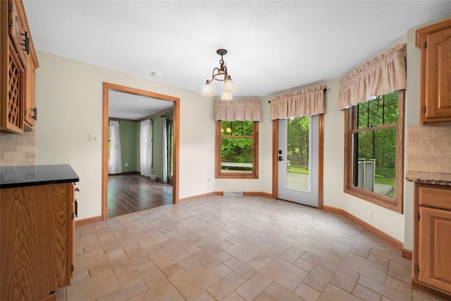 100 Firethorn Rd, Economy, PA 15005 - unfurnished dining area with healthy amount of natural light, baseboards, and a chandelier