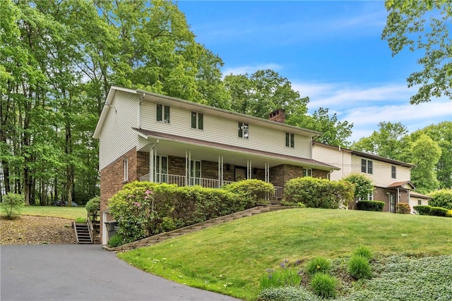 454 Cherokee Dr, Center Twp But, PA 16001 - traditional home featuring a front yard, a chimney, a porch, and brick siding