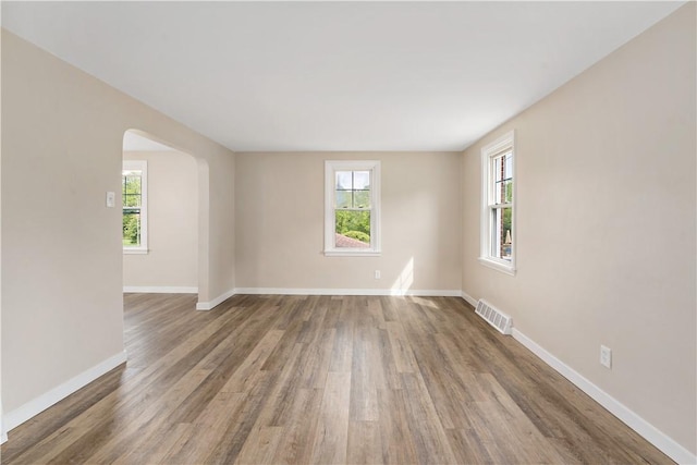 6225 Smithfield St, Elizabeth Twp/Boro, PA 15135 - unfurnished room featuring plenty of natural light, arched walkways, baseboards, and wood finished floors