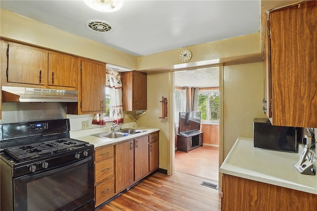 1406 Mccully Rd, Castle Shannon, PA 15234 - kitchen featuring black gas range, under cabinet range hood, a sink, and light countertops