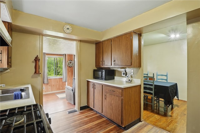 1406 Mccully Rd, Castle Shannon, PA 15234 - kitchen with black microwave, light wood finished floors, light countertops, brown cabinets, and a sink