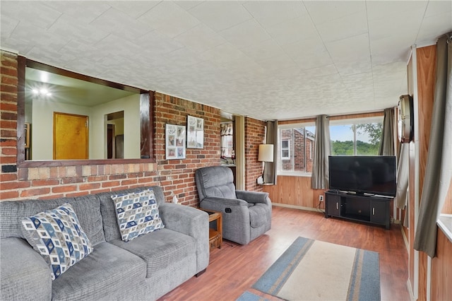 1406 Mccully Rd, Castle Shannon, PA 15234 - living area with wood finished floors, brick wall, and baseboards