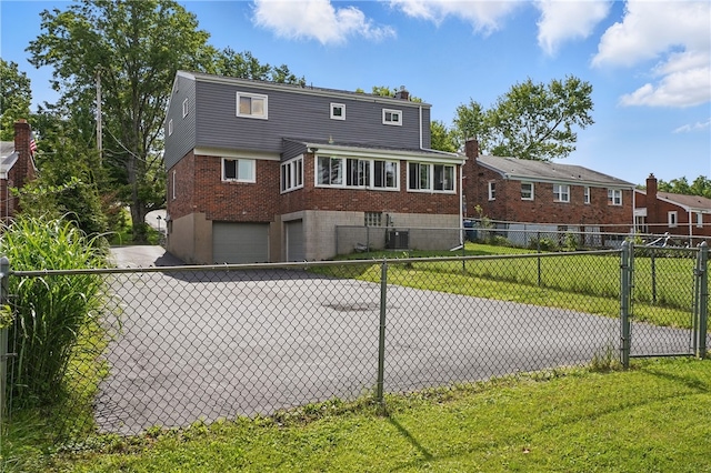 1406 Mccully Rd, Castle Shannon, PA 15234 - view of front facade featuring an attached garage, brick siding, a chimney, and central air condition unit
