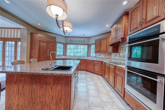 23 Pintail Dr, Indiana Twp Nal, PA 15238 - kitchen featuring a sink, double oven, brown cabinetry, black electric cooktop, and an island with sink