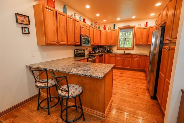 1147 Annisville Rd, Washington Twp But, PA 16050 - kitchen with stainless steel appliances, a sink, a peninsula, light wood-type flooring, and a kitchen breakfast bar