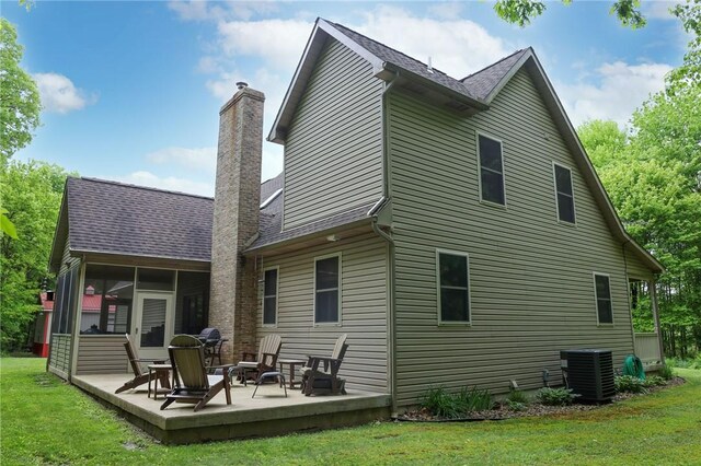 1147 Annisville Rd, Washington Twp But, PA 16050 - back of property with central air condition unit, a sunroom, a chimney, a lawn, and a patio area