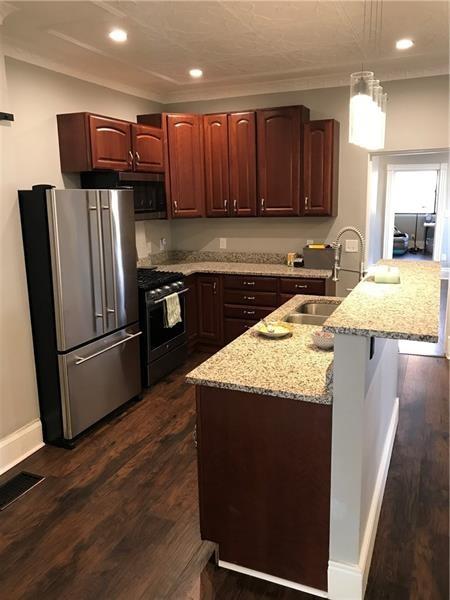 1124 Brabec St, Troy Hill, PA 15212 - kitchen featuring freestanding refrigerator, gas range oven, a sink, decorative light fixtures, and light stone countertops