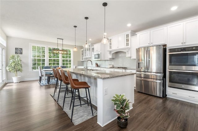 712 Mulkerrin Ct, Pine Twp Nal, PA 16046 - kitchen with appliances with stainless steel finishes, a sink, dark wood finished floors, light stone countertops, and a kitchen bar