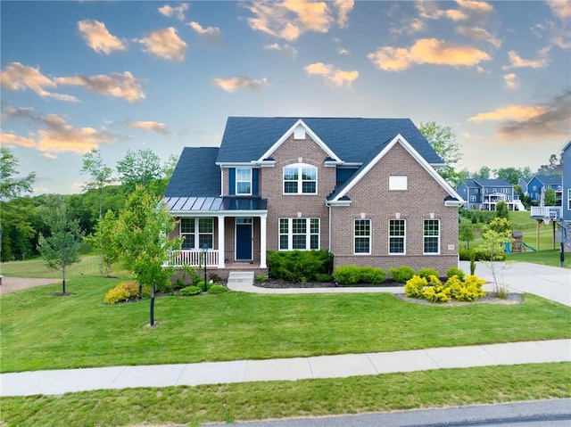 712 Mulkerrin Ct, Pine Twp Nal, PA 16046 - view of front of property featuring covered porch, brick siding, a front lawn, and a standing seam roof