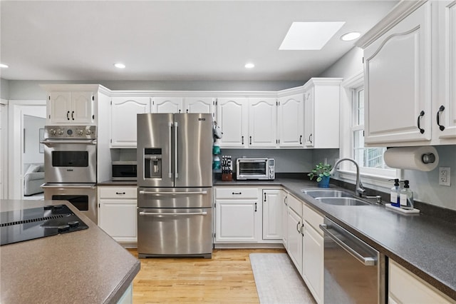 2455 Wedgewood Dr, Franklin Park, PA 15090 - kitchen with appliances with stainless steel finishes, a sink, a skylight, dark countertops, and recessed lighting