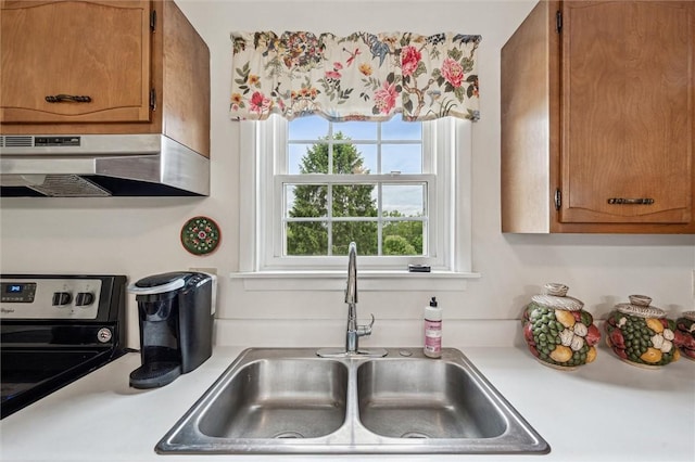 73 Hartman Rd, Green/Commdre/Prchse, PA 15759 - kitchen with a sink, stainless steel electric stove, light countertops, under cabinet range hood, and brown cabinets