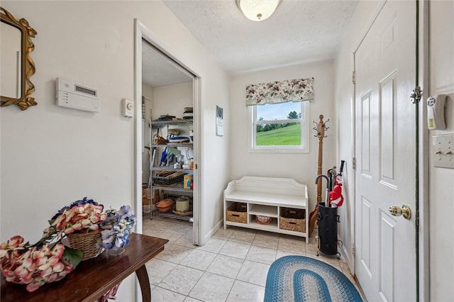 73 Hartman Rd, Green/Commdre/Prchse, PA 15759 - mudroom featuring a textured ceiling, light tile patterned floors, and baseboards