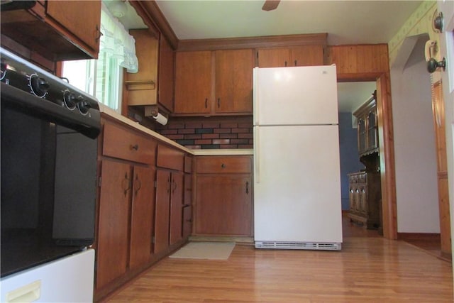 12840 Lincoln Way N, Huntingdon, PA 15642 - kitchen with freestanding refrigerator, oven, brown cabinets, and light wood-style floors