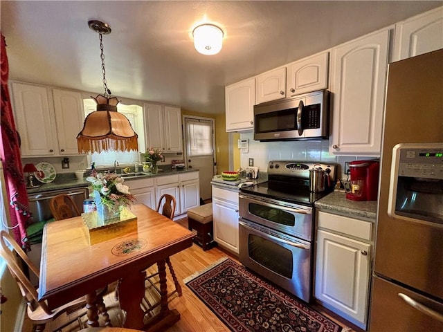 11 Worthington Ave, Neshannock Twp, PA 16105 - kitchen featuring stainless steel appliances, white cabinets, light wood-style flooring, backsplash, and a sink