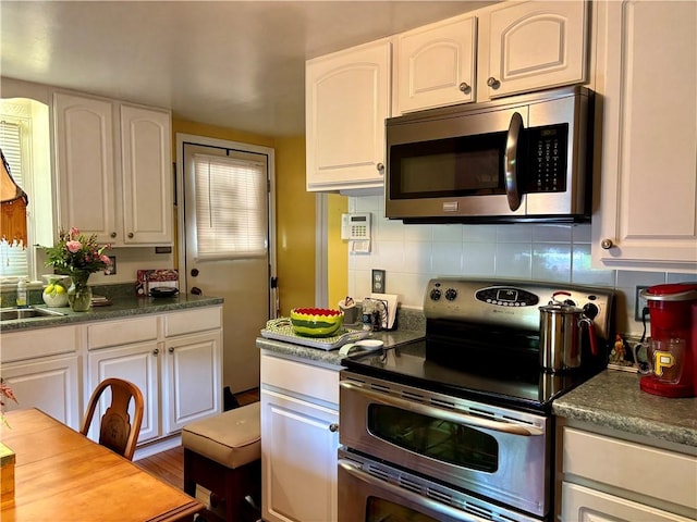 11 Worthington Ave, Neshannock Twp, PA 16105 - kitchen with appliances with stainless steel finishes, white cabinetry, tasteful backsplash, and dark countertops