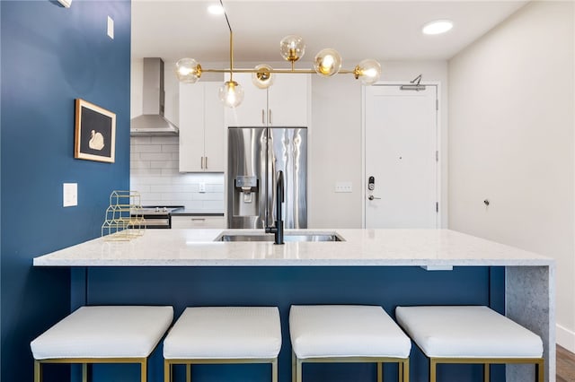 3725 Butler St Unit 406, Lawrenceville, PA 15201 - kitchen featuring wall chimney range hood, stainless steel refrigerator with ice dispenser, a sink, white cabinets, and backsplash