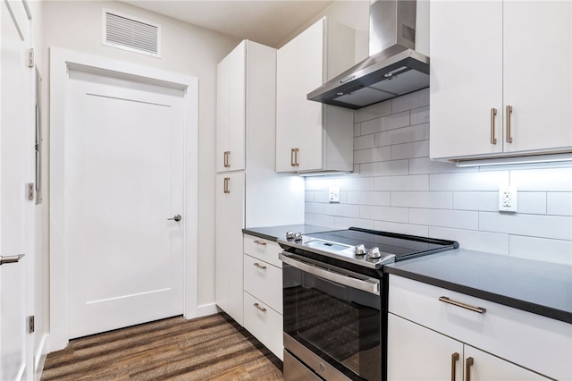 3725 Butler St Unit 406, Lawrenceville, PA 15201 - kitchen featuring wall chimney exhaust hood, stainless steel range with electric stovetop, dark wood finished floors, dark countertops, and white cabinets