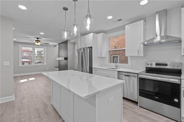 748 Anaheim St, Schenley Heights, PA 15219 - kitchen with appliances with stainless steel finishes, wall chimney exhaust hood, a sink, a center island, and white cabinetry