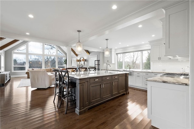 2293 Country Club Dr, Upper St Clair, PA 15241 - kitchen featuring a sink, dark wood finished floors, crown molding, a breakfast bar, and a kitchen island with sink