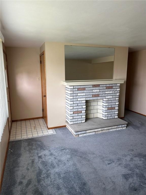 170 William Cir, Stowe Twp, PA 15136 - unfurnished living room featuring carpet flooring, baseboards, and a brick fireplace