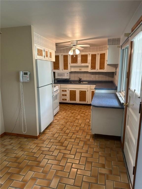 170 William Cir, Stowe Twp, PA 15136 - kitchen with white appliances, dark countertops, a ceiling fan, a sink, and baseboards