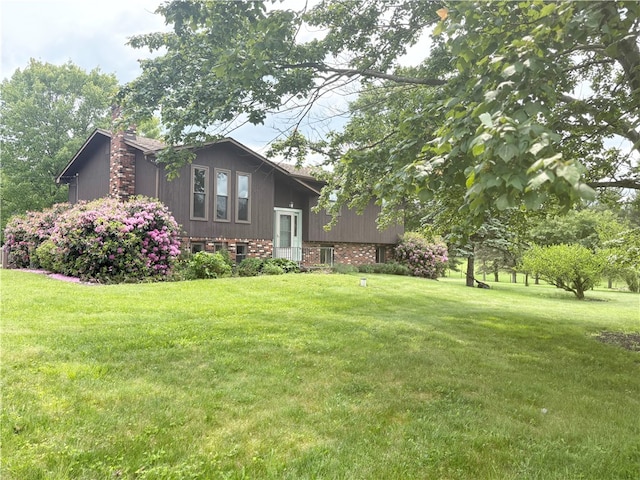 199 Lyon Ln, Lancaster Twp, PA 16037 - view of home's exterior featuring a chimney, a yard, and brick siding
