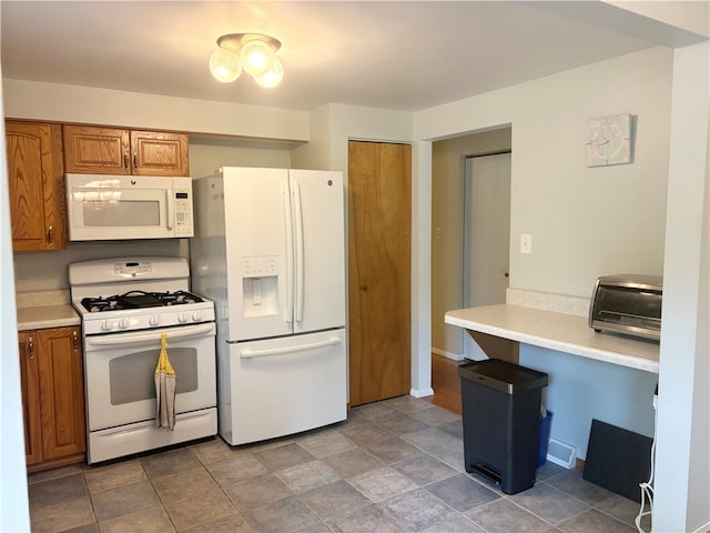 199 Lyon Ln, Lancaster Twp, PA 16037 - kitchen with white appliances, brown cabinetry, light countertops, and stone finish floors