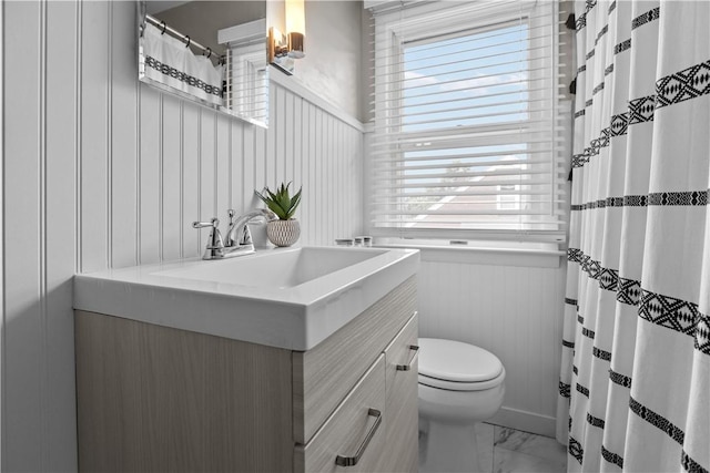 1311 Agnew Ave, Hopewell Twp Bea, PA 15001 - bathroom with marble look tiles, vanity, toilet, healthy amount of natural light, and a wainscoted wall