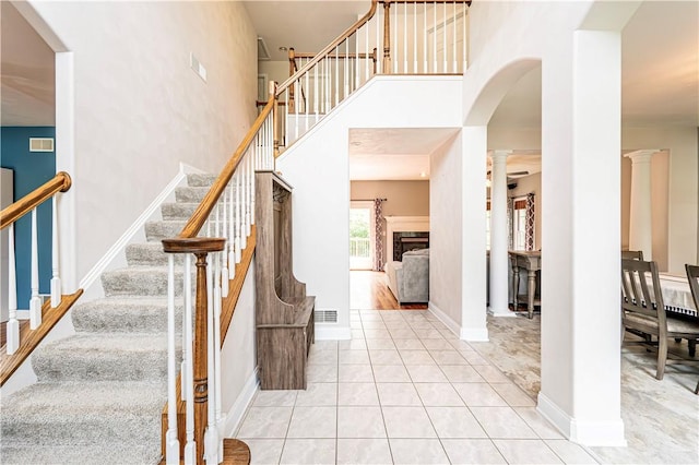 1500 Fitzgerald Ct, Unity Twp, PA 15601 - staircase featuring decorative columns, tile patterned flooring, a high ceiling, and baseboards