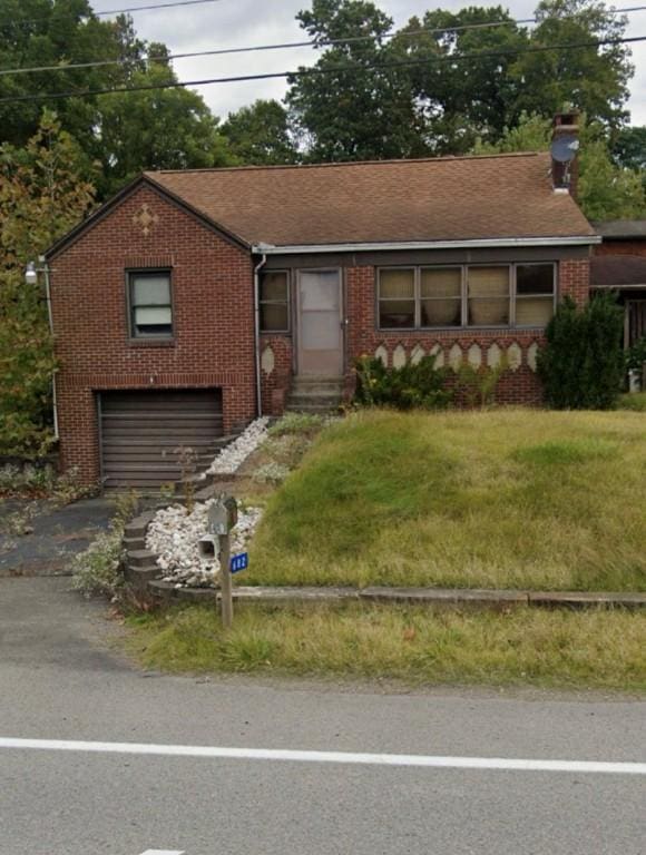 2682 River Rd, Pa, PA 15690 - ranch-style house with asphalt driveway, brick siding, an attached garage, and a chimney