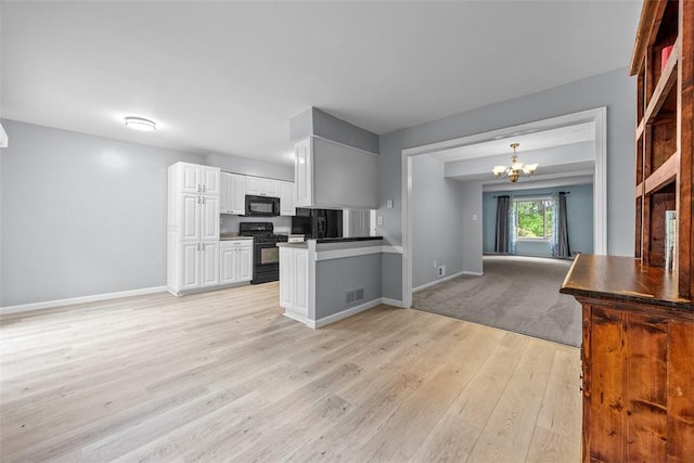 402 Hunting Creek Rd, Canonsburg, PA 15317 - kitchen featuring black appliances, white cabinets, light wood-type flooring, open floor plan, and a chandelier